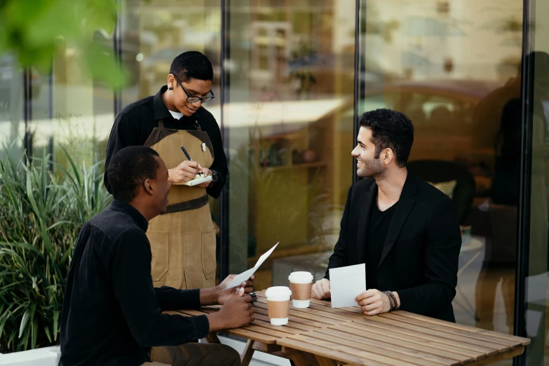 a group of men sitting around a wooden table, coffee shop, professional image, thumbnail, high quality image