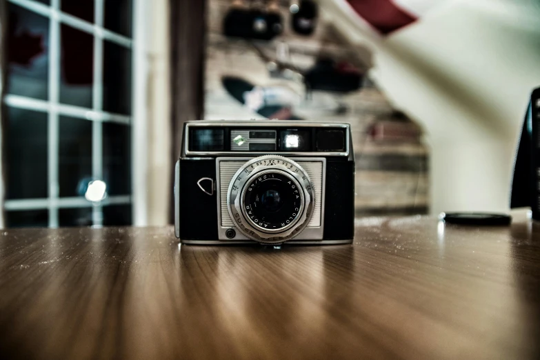 a camera sitting on top of a wooden table, a picture, by Adam Marczyński, retro photography, highly polished, ecommerce photograph, amateur photograph