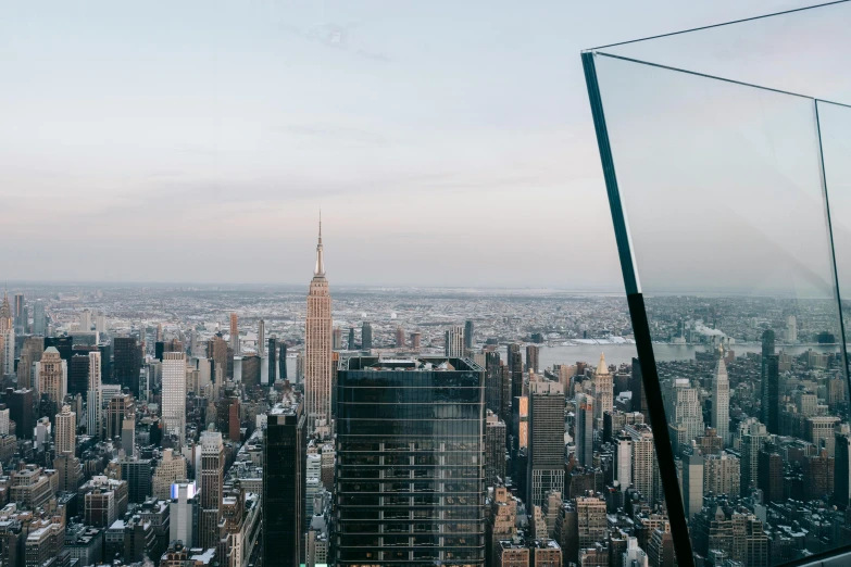 a view of a city from the top of a building, pexels contest winner, huge glass structure, new york backdrop, side profile shot, tall obsidian architecture