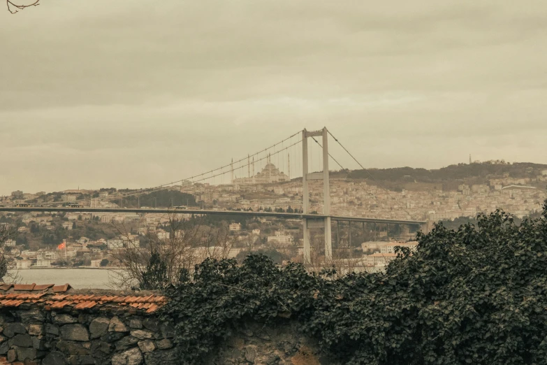 a view of a bridge over a body of water, inspired by Elsa Bleda, pexels contest winner, fallout style istanbul, city on a hillside, grey, brown