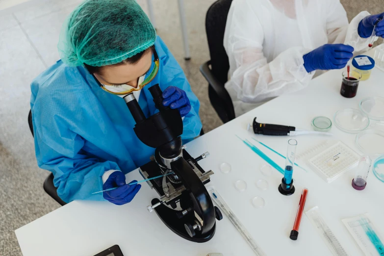 a couple of people sitting at a table with microscopes, a microscopic photo, by Adam Marczyński, pexels contest winner, medical labels, surgical gear, thumbnail, restoration