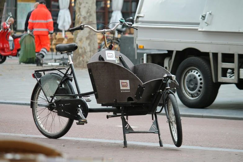a bicycle is parked on the side of the road, dutch style, carriage full of computers, toddler, thumbnail