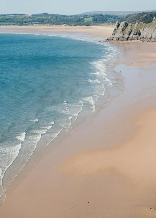 a large body of water next to a sandy beach, by Nina Hamnett, pexels contest winner, omaha beach, crystal clear blue water, subtle colors, arial shot