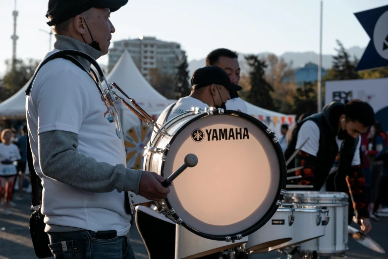 a man that is standing next to a drum, band playing, formula 1, profile image, parade setting