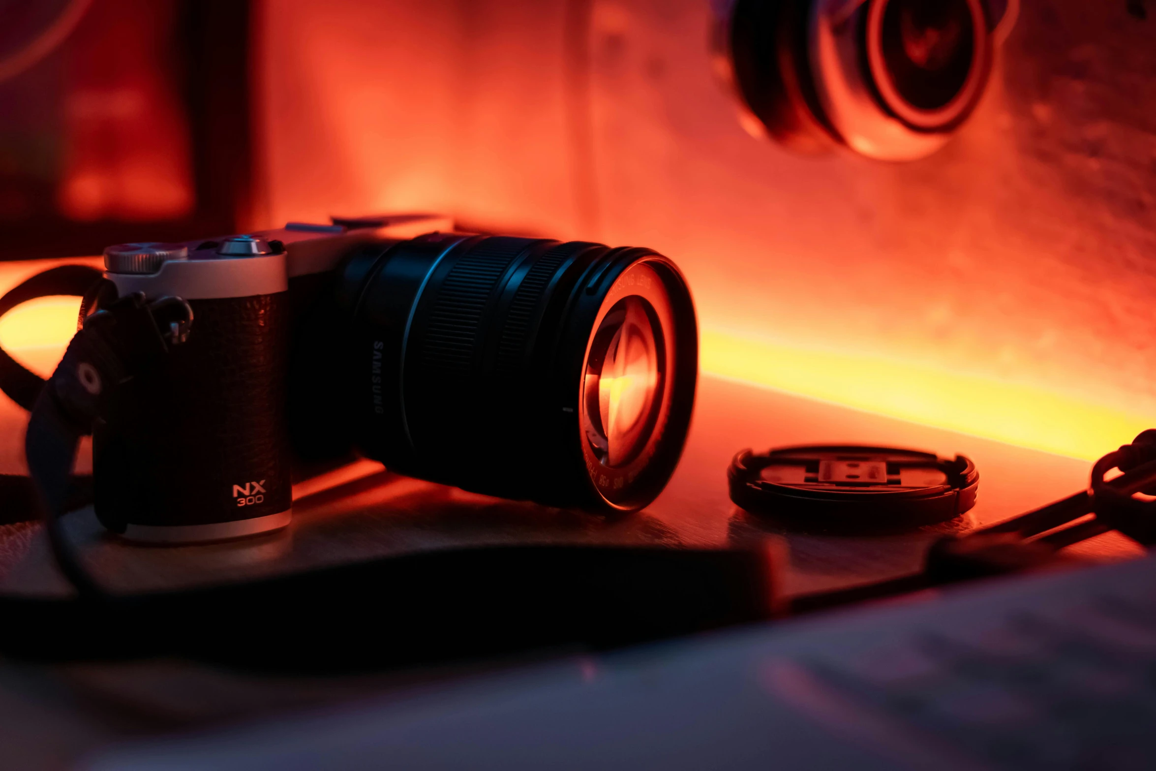 a camera sitting on top of a counter next to a clock, pexels contest winner, art photography, red and orange glow, flares anamorphic, looking into camera, close up camera on bonfire level