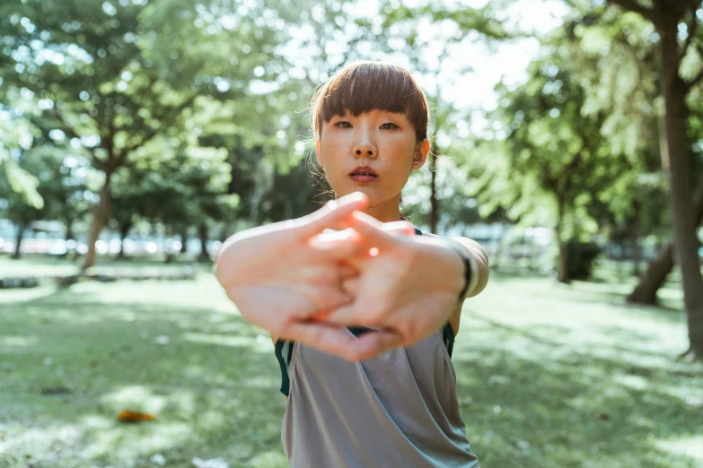 a woman throwing a frisbee in a park, pexels contest winner, hands pressed together in bow, kimitake yoshioka, centered portrait, pixeled stretching