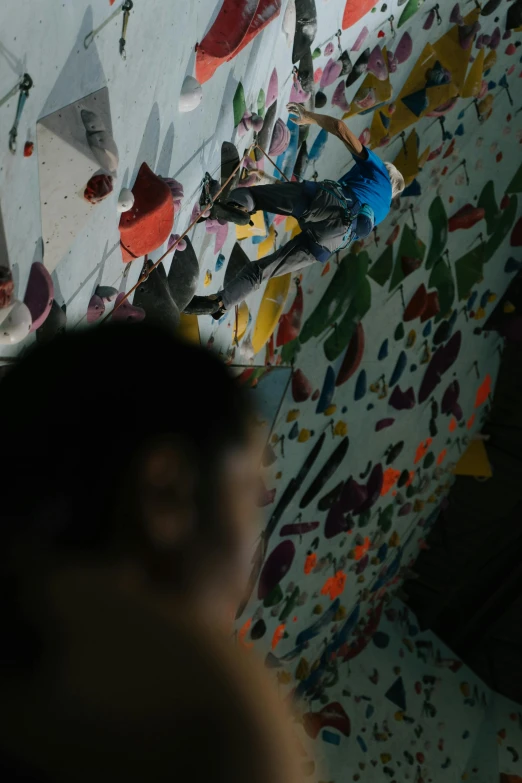 a person standing in front of a climbing wall, reuben wu, down there, blurry, gnarly