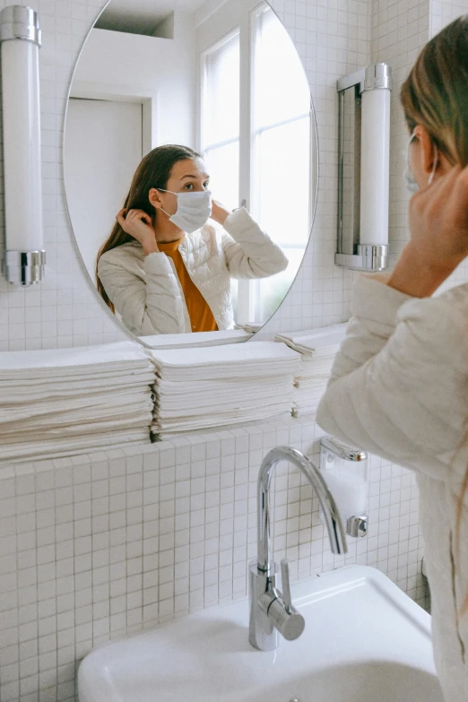 a woman standing in front of a mirror brushing her hair, by Nicolette Macnamara, pexels contest winner, happening, surgical mask covering mouth, profile image, made of lab tissue, tourist photo