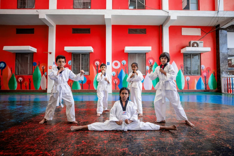 a group of people doing karate in front of a building, a portrait, pexels contest winner, bengal school of art, kid, patriotism, award winning masterpiece photo, image