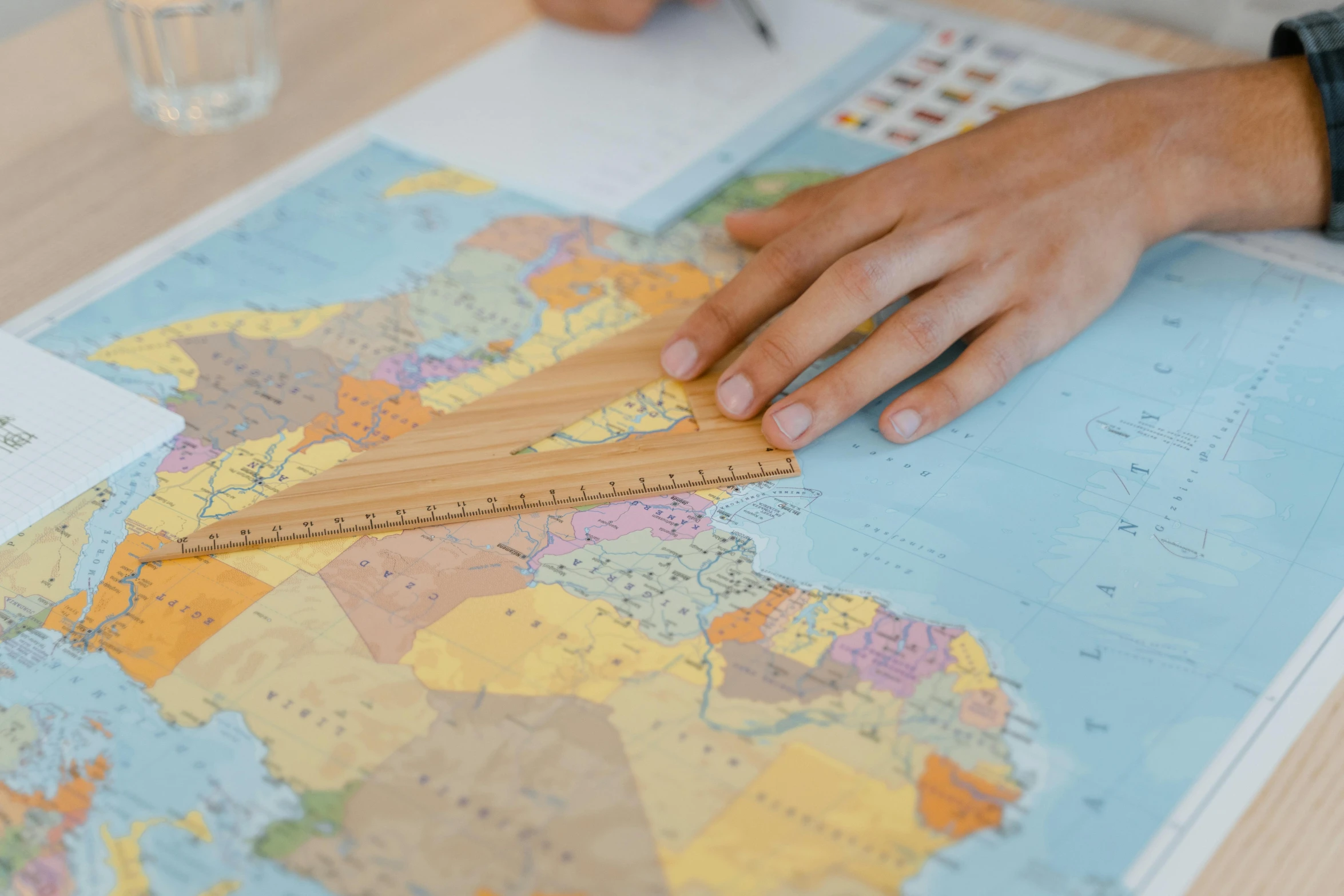 a person holding a ruler on top of a map, profile image, board games on a table, zoomed out to show entire image, thumbnail