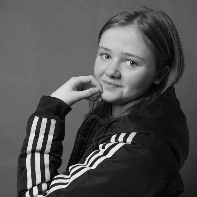 a black and white photo of a young girl, by Emma Andijewska, wearing a tracksuit, professional profile picture, character headshot portrait, teen girl