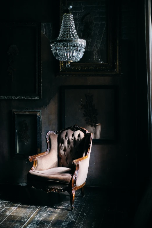 a chair and a chandelier in a dark room, inspired by Elsa Bleda, unsplash contest winner, baroque, tufted softly, portrait of an old, warmly lit posh study, ornate frame