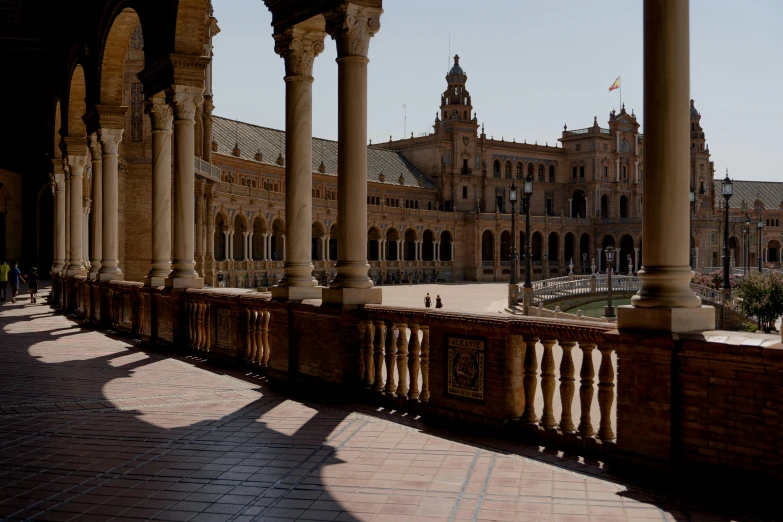 a large building with columns and a clock tower, inspired by Luis Paret y Alcazar, pexels contest winner, archways between stalagtites, terrace, profile image, square