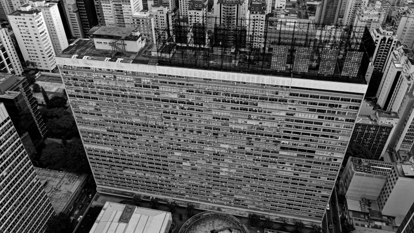 a clock that is on the side of a building, a black and white photo, inspired by Andreas Gursky, pexels contest winner, brutalism, aerial view. hand stitching, kowloon walled city, são paulo, united nations