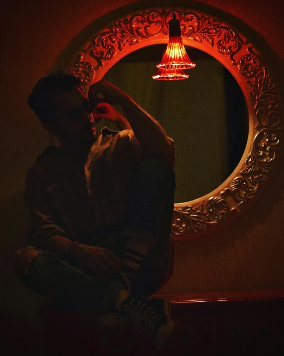 a man that is sitting in front of a mirror, an album cover, by Elsa Bleda, unsplash, hurufiyya, red lights, bisexual lighting, profile image, posing for a picture