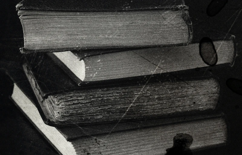 a stack of books sitting on top of a table, an etching, pexels, tonalism, close-up print of fractured, grainy black-and-white photo, detail, 1 9 5 6