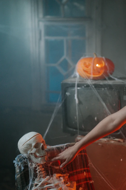 a woman sitting on top of a couch next to a skeleton, inspired by Elsa Bleda, pexels contest winner, pumpkins, spraying liquid, ( ( theatrical ) ), gif