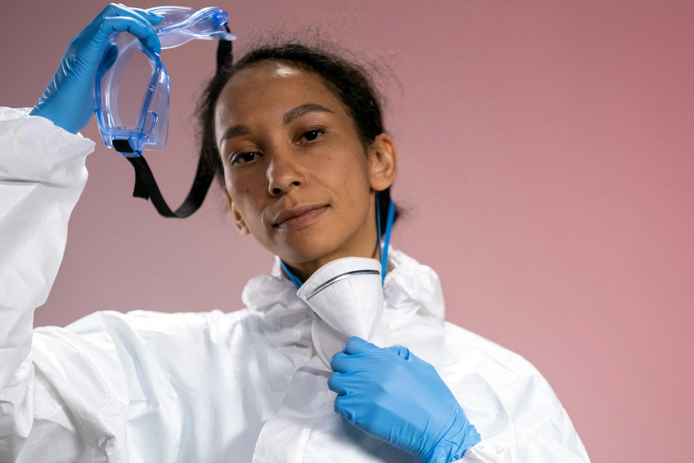 a woman in a lab coat holding a pair of goggles, a portrait, pexels contest winner, plasticien, hito steyerl, respirator, ameera al-taweel, thumbnail