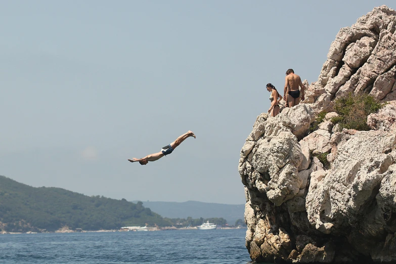 a man jumping off a cliff into the ocean, by Jan Rustem, pexels contest winner, figuration libre, croatian coastline, people swimming, thumbnail, limestone
