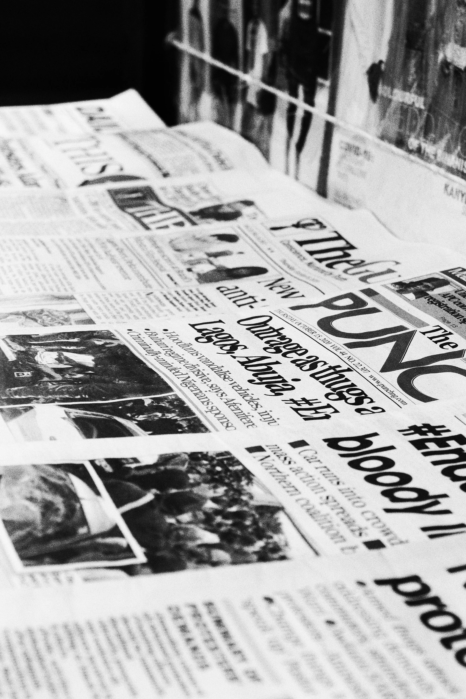 a pile of newspapers sitting on top of a table, a black and white photo, promo image, wlup, the beginning and the end, funky