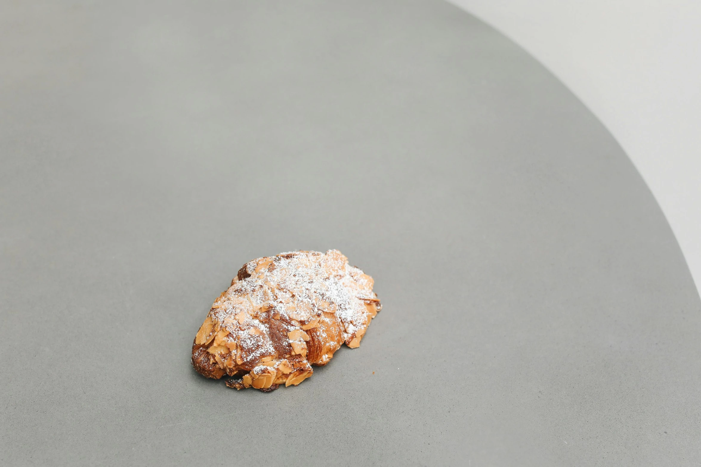 a cookie sitting on top of a table covered in powdered sugar, inspired by Richmond Barthé, arabesque, unrefined sparkling gold nugget, medium height, rocky roads, on grey background