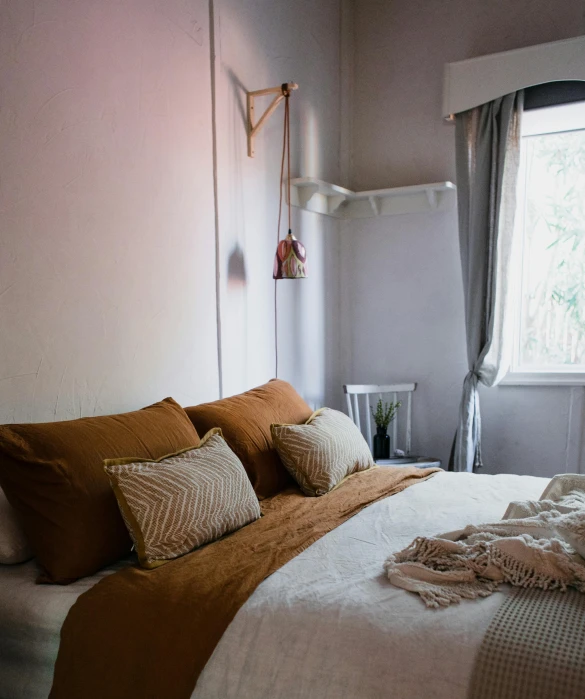 a bed room with a neatly made bed and a window, by Jessie Algie, trending on unsplash, ocher details, gradient brown to white, low quality photo, cushions