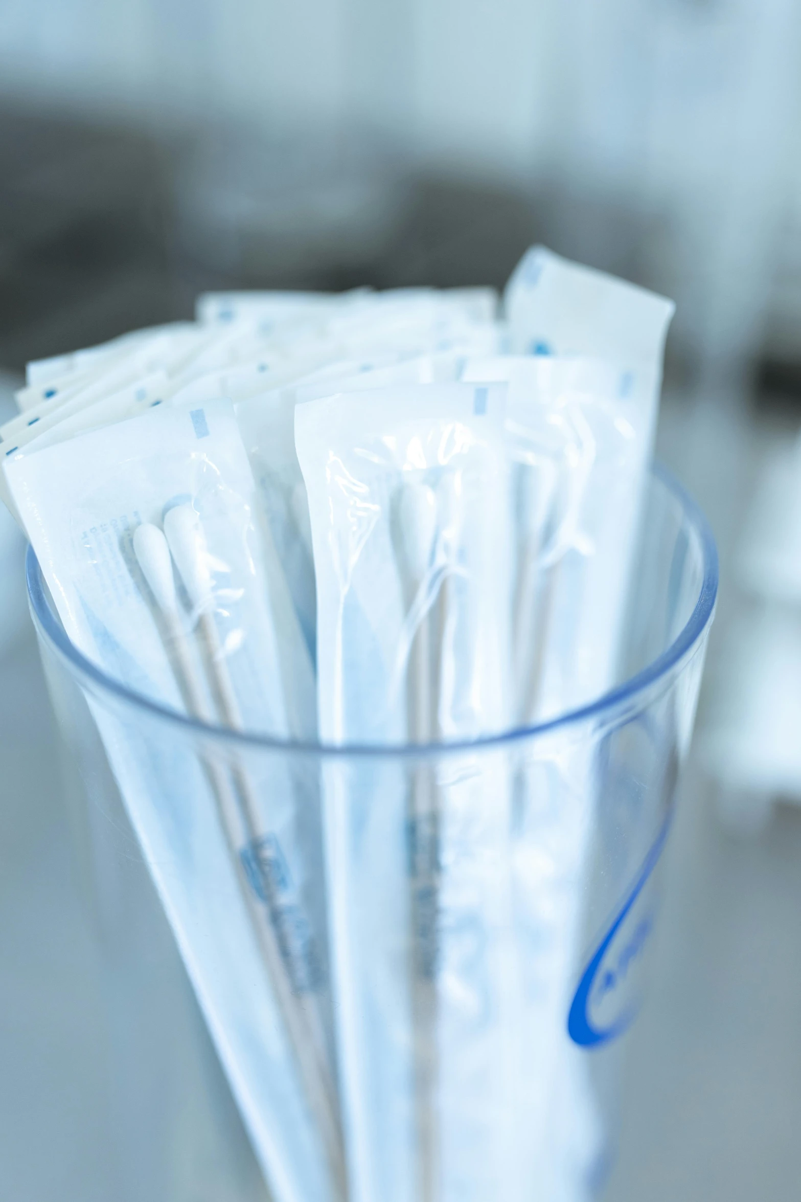 a glass filled with toothbrushes sitting on top of a counter, plasticien, 4 0 0 0 samples, surgical iv bag, stainless steel, white