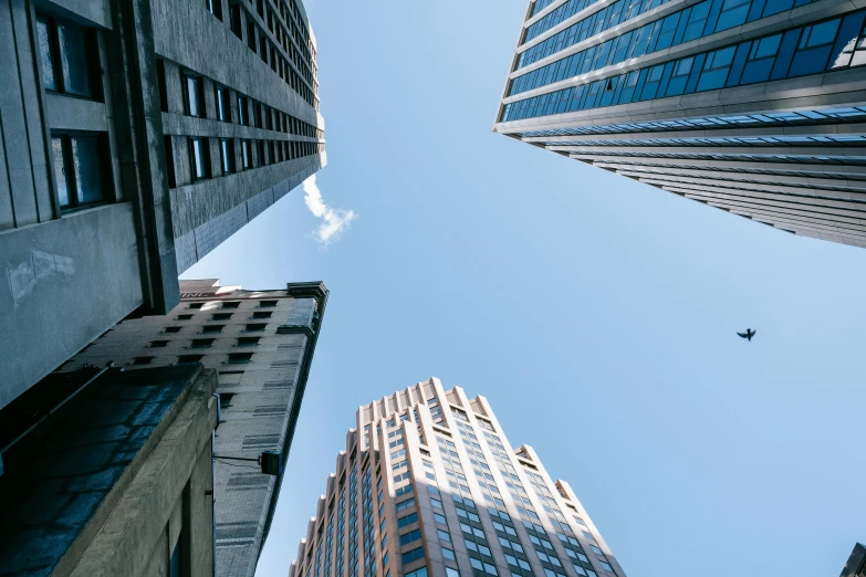 a group of tall buildings next to each other, by Adam Rex, pexels contest winner, clear blue sky, high angle vertical, looking upwards, corporate memphis