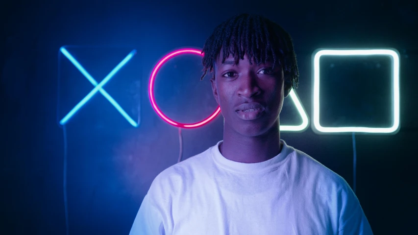a young man standing in front of a neon sign, inspired by Xanthus Russell Smith, pexels contest winner, lyco art, chief keef, adut akech, shot in the photo studio, kaws