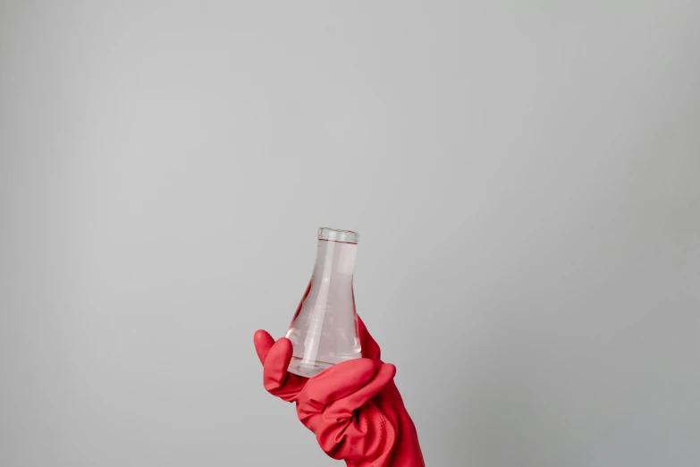 a person in a red glove holding a bottle of water, unsplash, plasticien, beakers, white and pink cloth, hegre, 1759