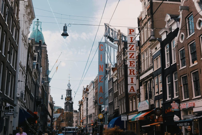 a group of people walking down a street next to tall buildings, by Jan Tengnagel, pexels contest winner, art nouveau, view of houses in amsterdam, lots of signs and shops, 🚿🗝📝, thumbnail