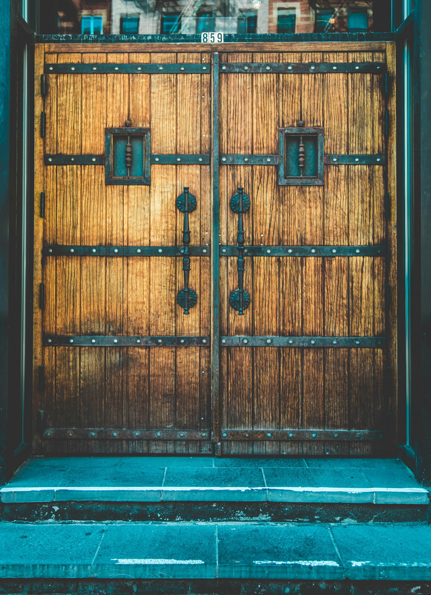 a large wooden door on the side of a building, an album cover, unsplash, arts and crafts movement, square, cinematic photo, high quality photo, metal framed portal