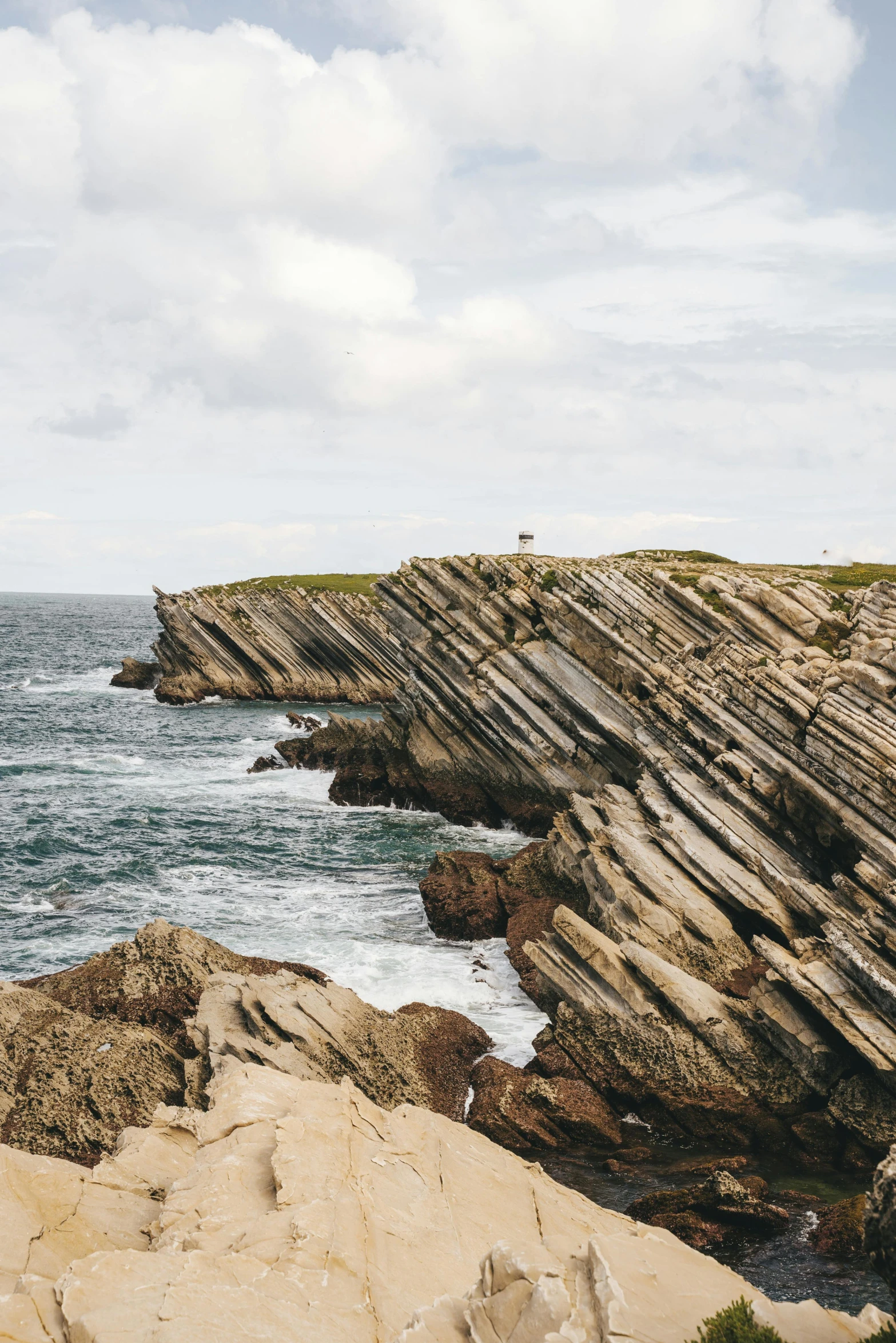 a man standing on top of a cliff next to the ocean, les nabis, chiseled formations, vivid lines, university, port