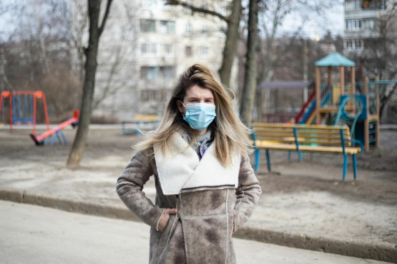 a woman wearing a face mask in a park, a portrait, by Julia Pishtar, silent hill in real life, standing in township street, danila tkachenko, scientific
