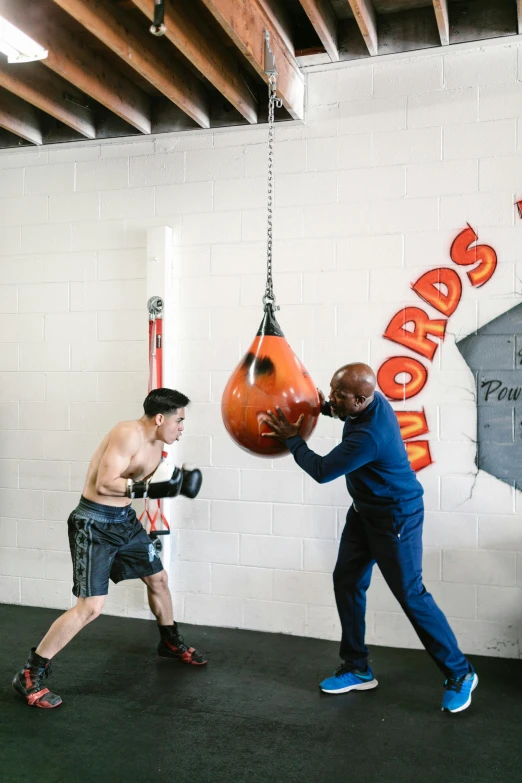 two men are practicing boxing in a gym, a photo, by Anson Maddocks, big drops of sweat, lewis jones, punching in a bag, a bald