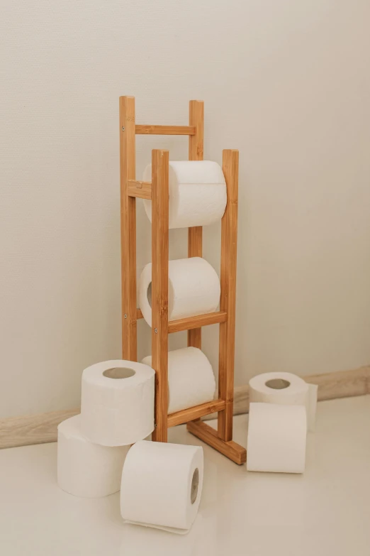 a bunch of rolls of toilet paper sitting on top of a wooden stand, inspired by Sarah Lucas, unsplash, conceptual art, 3 - piece, bamboo, product view, mid body