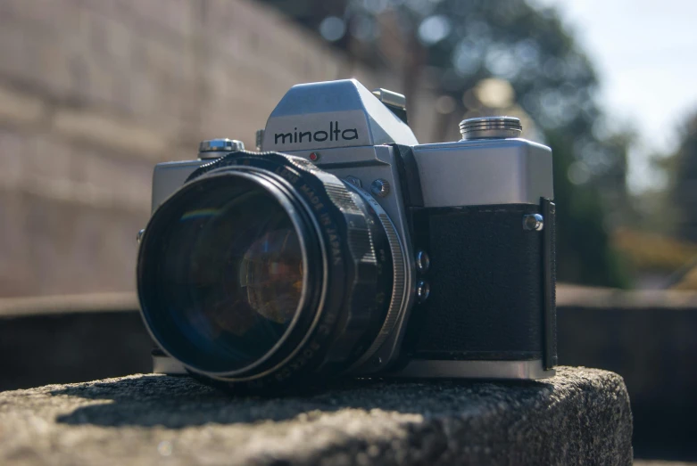 a camera sitting on top of a cement slab, a picture, unsplash contest winner, photorealism, konica minolta, anamorphic bokeh and lens flares, medium format, front facing the camera
