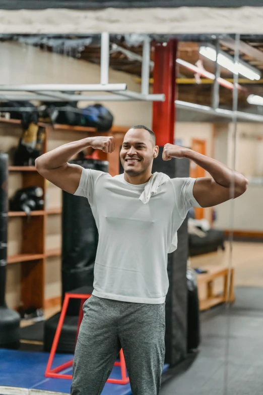 a man flexing his muscles in a gym, a portrait, by Austin English, pexels contest winner, happening, jayson tatum, wholesome, athletic crossfit build, smiling and dancing