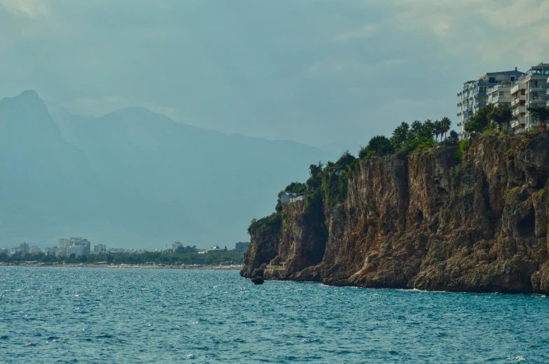 a large body of water with a mountain in the background, a matte painting, by Elsa Bleda, pexels contest winner, hurufiyya, coastal cliffs, marbella, view from the sea, today\'s featured photograph 4k