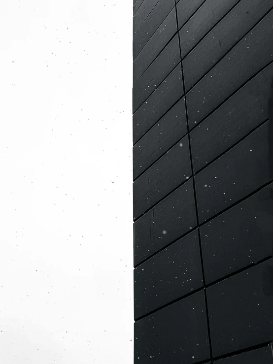 a man flying through the air while riding a snowboard, a black and white photo, by Jacob Toorenvliet, unsplash, postminimalism, metal cladding wall, window ( rain ), clean detail 4k, ((monolith))