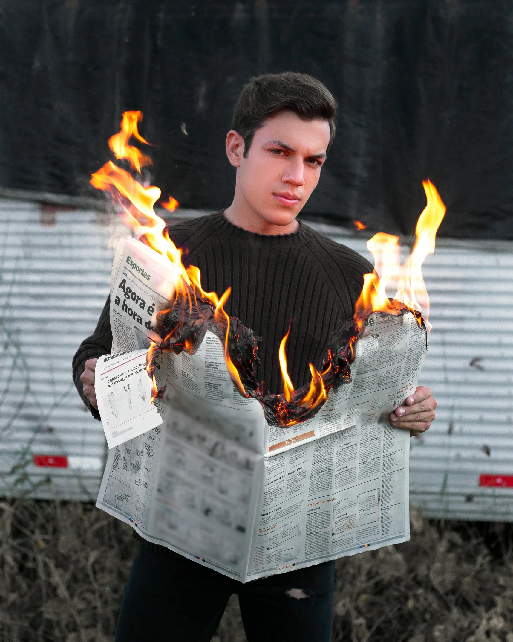 a man holding a newspaper with fire coming out of it, an album cover, trending on reddit, an epic non - binary model, tom holland, photobash, ignant