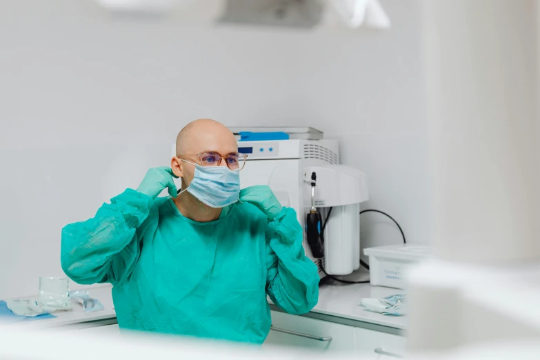 a person wearing a surgical mask in a room, a picture, by Adam Marczyński, pexels contest winner, dentist, wearing small round glasses, avatar image, histological