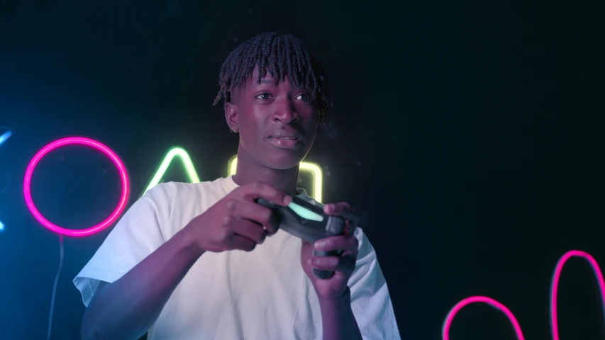 a man holding a video game controller in front of a neon sign, pexels contest winner, afrofuturism, black teenage boy, low quality photo, adut akech, mid shot photo