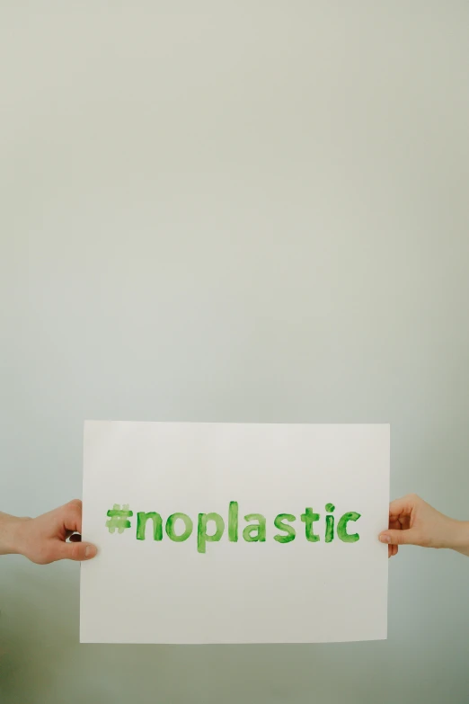 two people holding a sign that says noplastic, trending on unsplash, neoplasticism, hot glue, #green, instagram post, stop motion