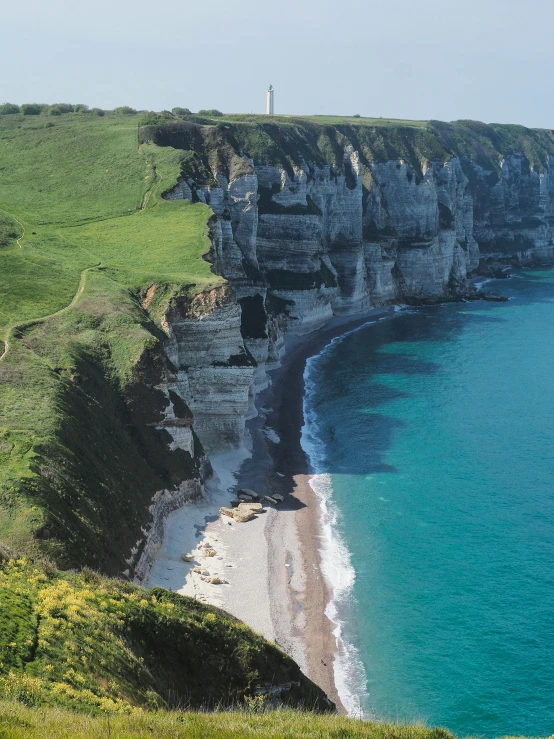 a couple of sheep standing on top of a lush green hillside, an album cover, by Raphaël Collin, pexels contest winner, les nabis, storming the beaches of normandy, cliffs, panorama, the village on the cliff