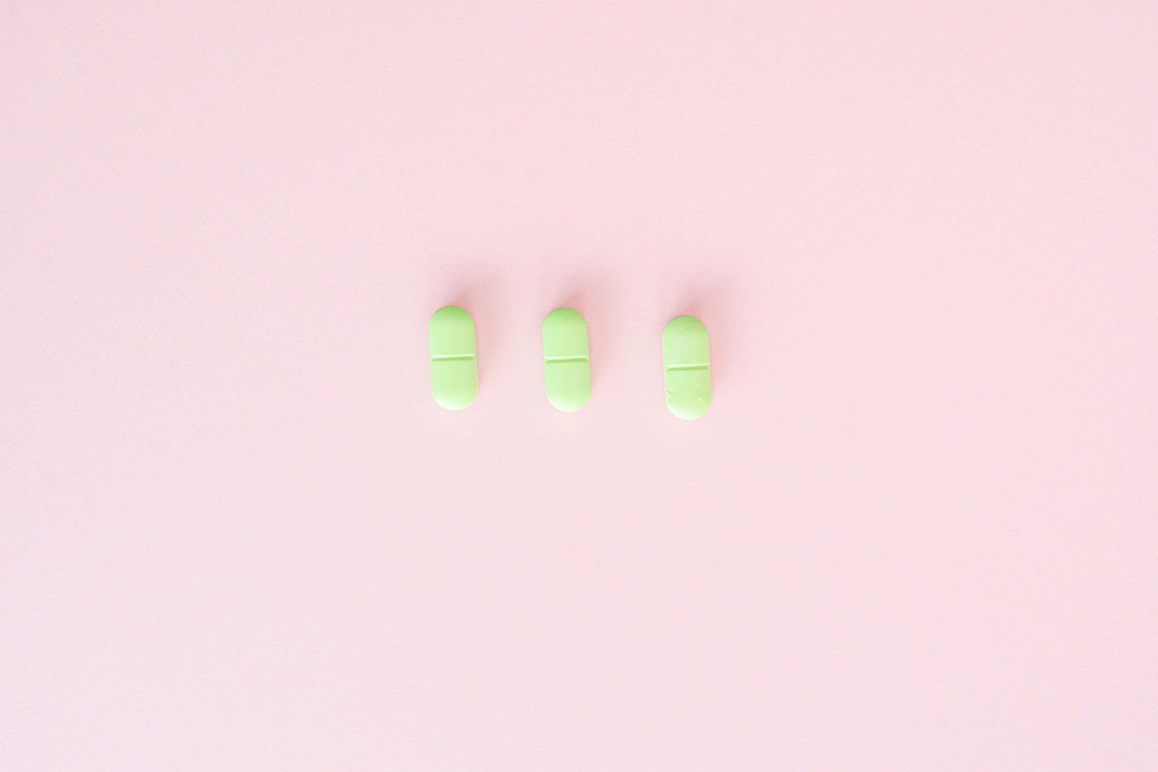three green pills on a pink background, unsplash, candy worms, minimalism, dezeen, rinko kawauchi