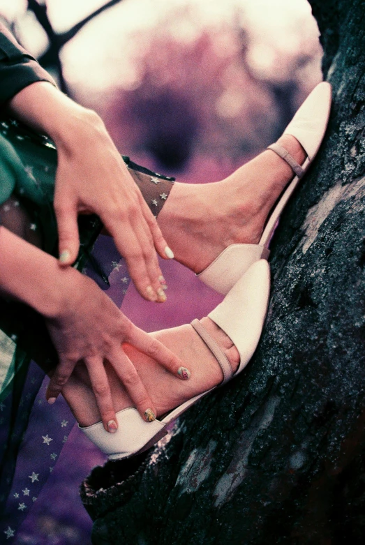 a close up of a person holding a pair of shoes, inspired by Oleg Oprisco, magic realism, bangles, **cinematic, sales, sitting on a tree