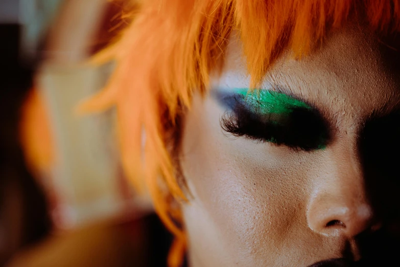 a close up of a person with orange hair, an album cover, trending on pexels, kabuki makeup, emerald eyes, taken with sony alpha 9, leeloo