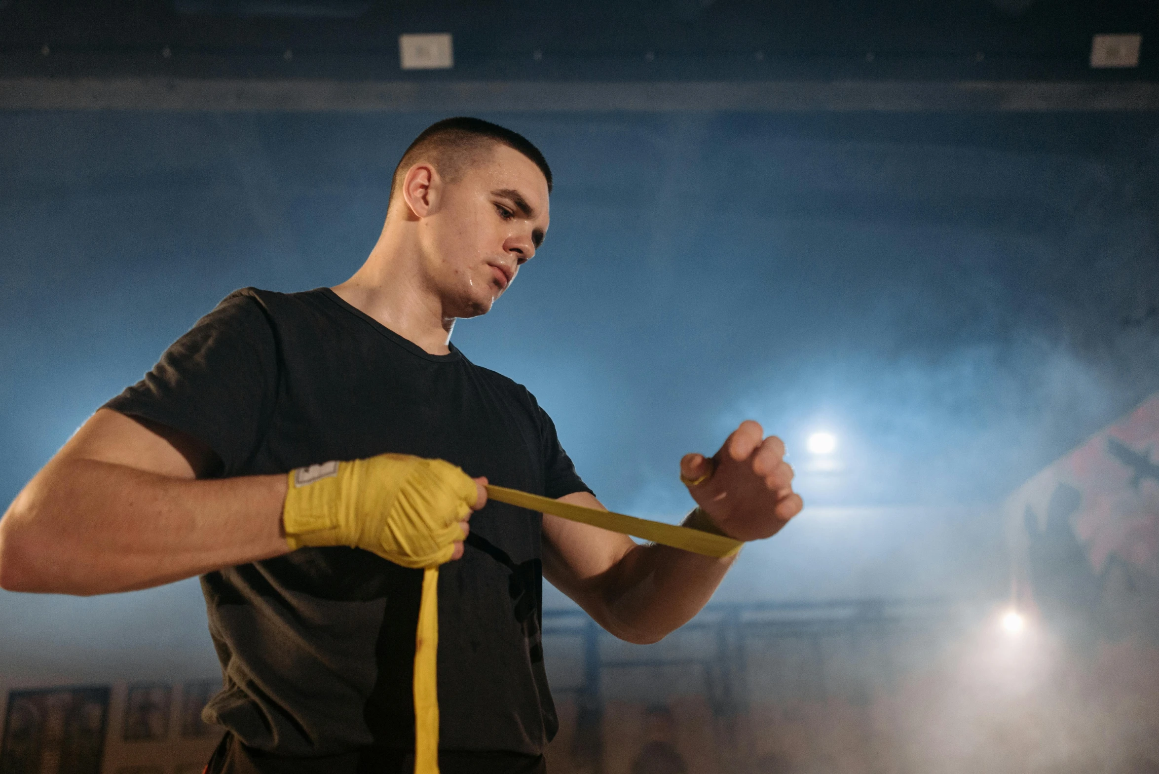 a man in a black shirt holding a yellow rope, pexels contest winner, hand wraps, performance, avatar image, hasbulla magomedov