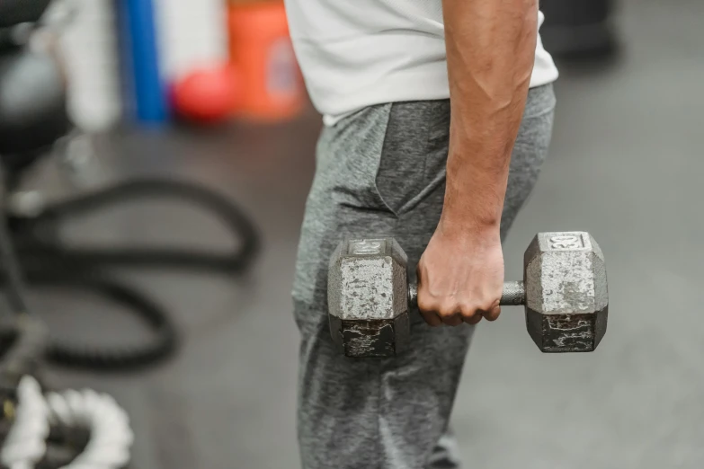 a man holding a pair of dumbs in a gym, pexels contest winner, 🦩🪐🐞👩🏻🦳, athletic muscle tone, pulling strings, six sided